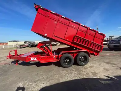 Red J&C dump trailer with the bed raised