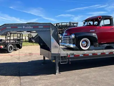 Gooseneck flatbed hauling a classic truck